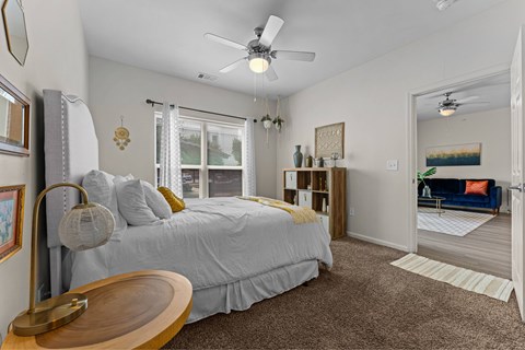 A bedroom with a large bed and a ceiling fan.