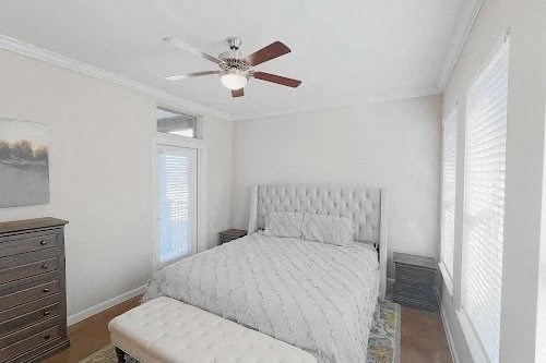 A bedroom with a bed, dresser, and window. at Bridge at Heritage Woods, Austin, TX, 78753