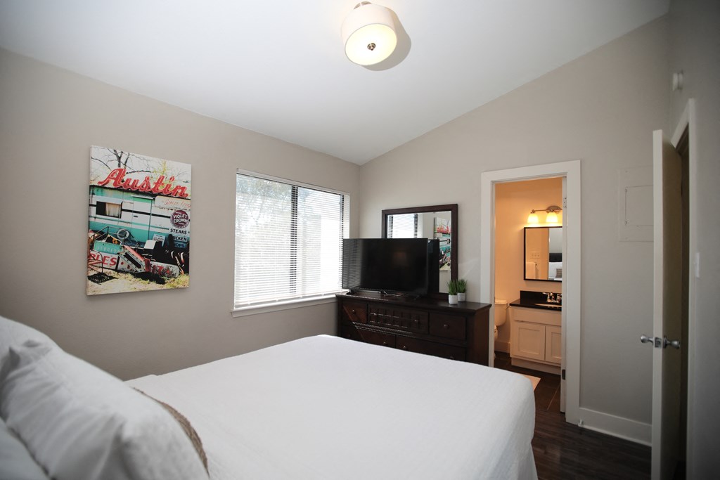 a bedroom with a bed and a dresser and a tv