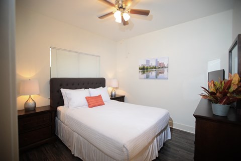 a bedroom with a large white bed and a ceiling fan