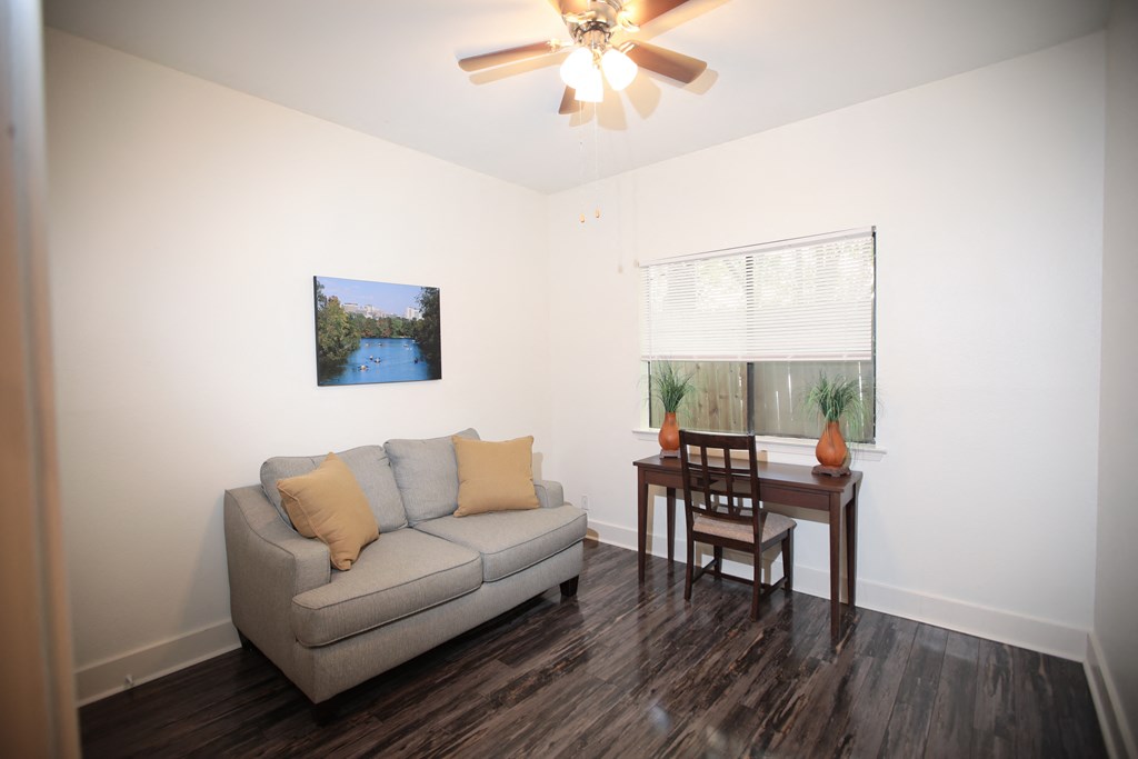 a living room with a couch and a table and a ceiling fan