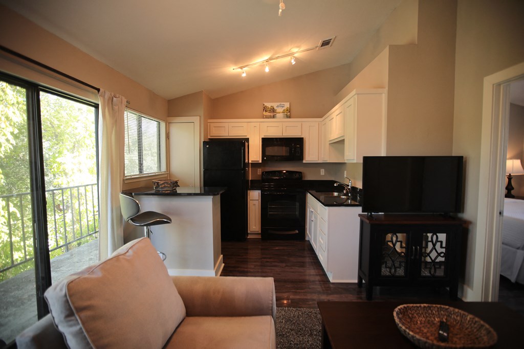 an open kitchen and living room with a couch and a table