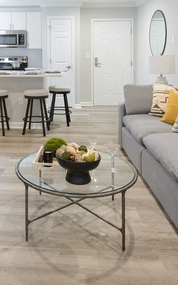 a living room with a couch and a table with a bowl of fruit on it