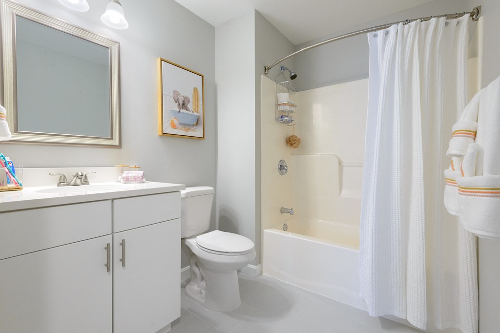 a bathroom with a white toilet next to a white bathtub with a shower curtain