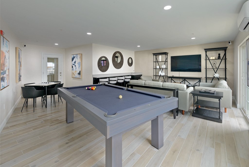 a games room with a blue pool table in the middle of a room