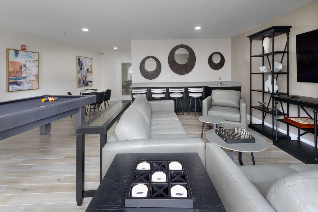 a living room filled with furniture and a pool table