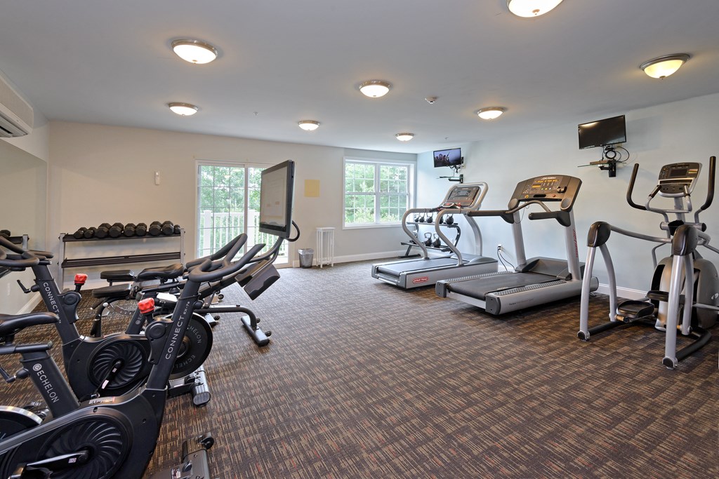 a room filled with cardio equipment and a flat screen tv