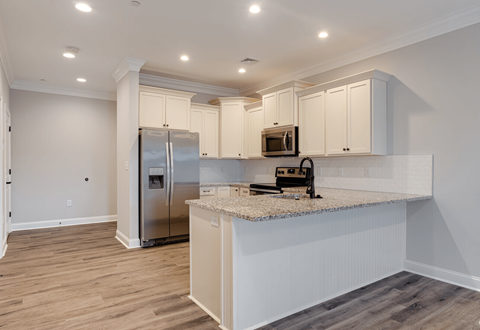 a kitchen with an island and a stainless steel refrigerator