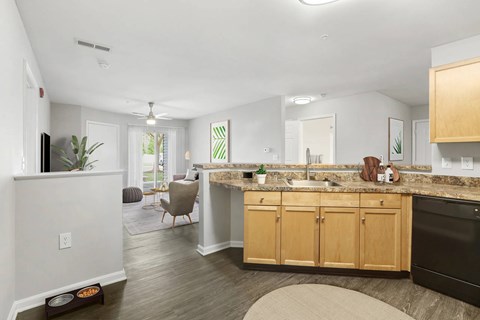 A kitchen with wooden cabinets and a black dishwasher.