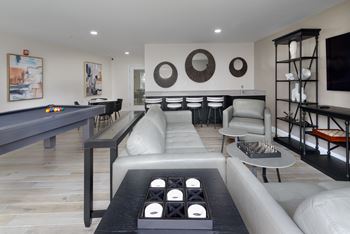 a living room filled with furniture and a pool table