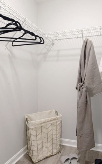 a walk in closet with a basket and hangers
