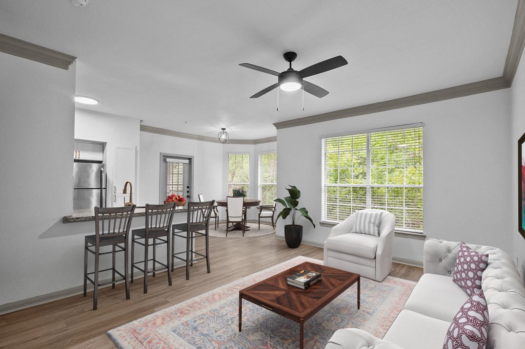 a living room with a white couch and a table with chairs at The Aster Sugar Land, Texas