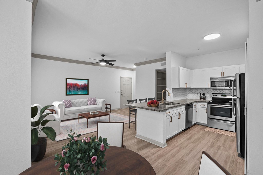 white living room and kitchen with island and dining room table and couch at The Aster Sugar Land, Texas