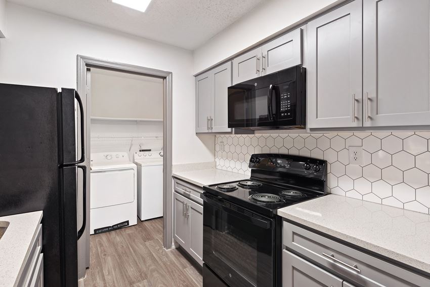 Renovated Kitchen with Black Appliances, Tile Backsplash and access to in-unit washer and dryer located at 1900 Rosemont in Roswell, GA 30076 - Photo Gallery