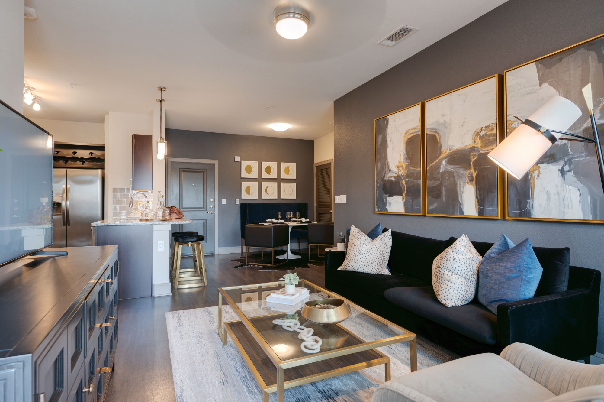 A modern living room with a black couch and a coffee table.