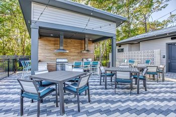 a patio with tables and chairs and a pergola at The Beck at Hidden River, Tampa, Florida