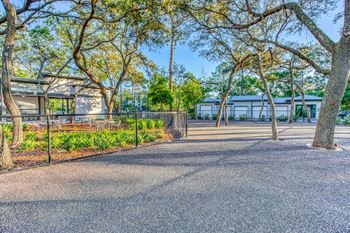 a courtyard with trees and a fence at The Beck at Hidden River, Tampa, FL, Florida