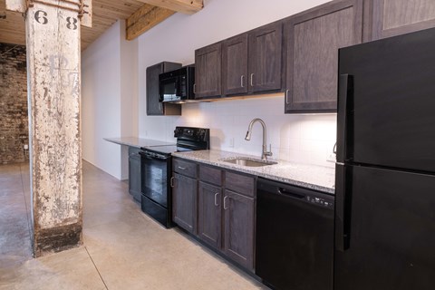 a kitchen with black appliances and wooden cabinets