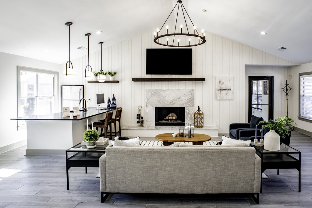 a living room with a fireplace and a kitchen in the background