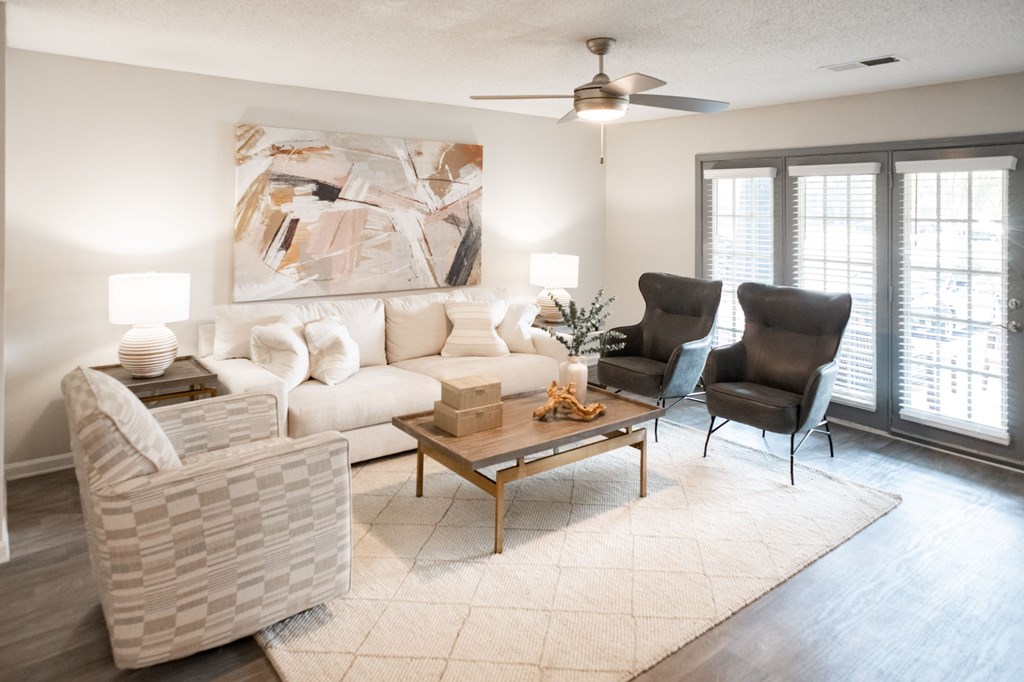 A living room with a white couch, a chair, and a table with a vase on it. at The Addison at Collierville, Collierville, Tennessee