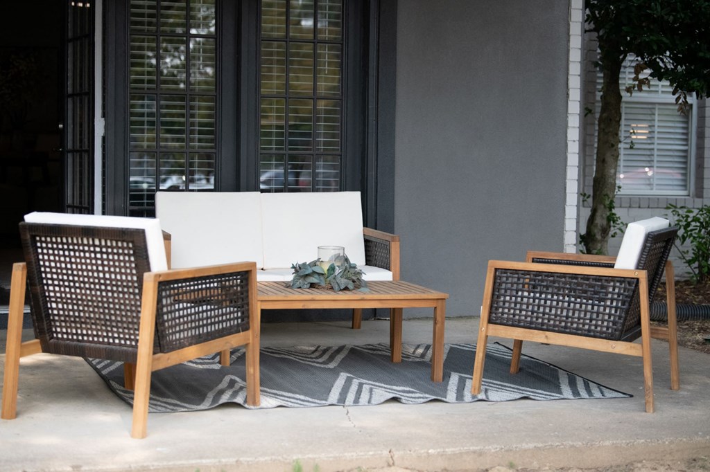 A patio with a white couch, two chairs and a coffee table. at The Addison at Collierville, Collierville
