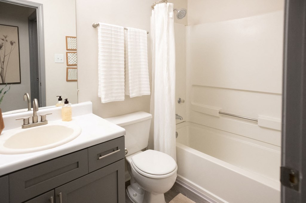 A white bathroom with a toilet, sink, and bathtub. at The Addison at Collierville, Collierville, 38017