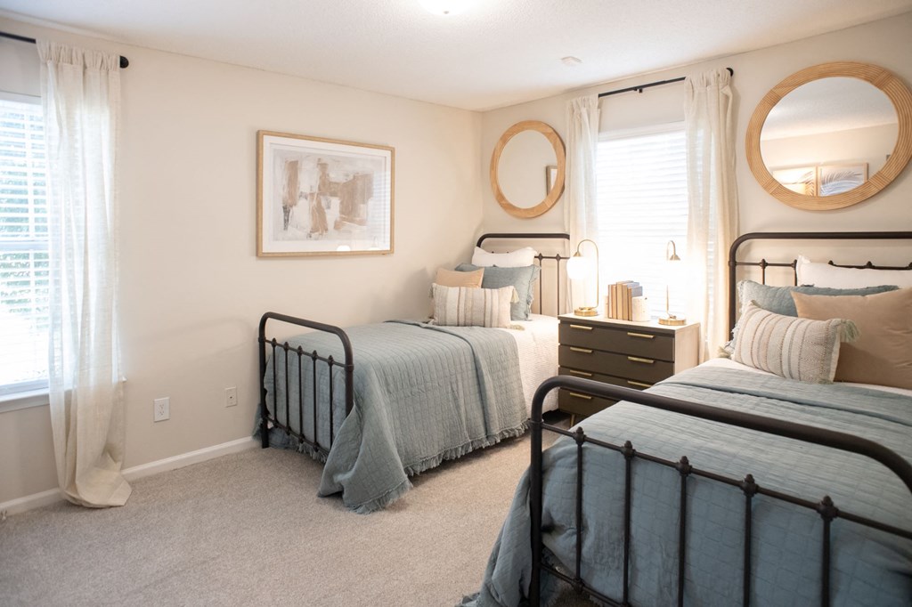 A bedroom with two beds and a dresser. at The Addison at Collierville, Collierville