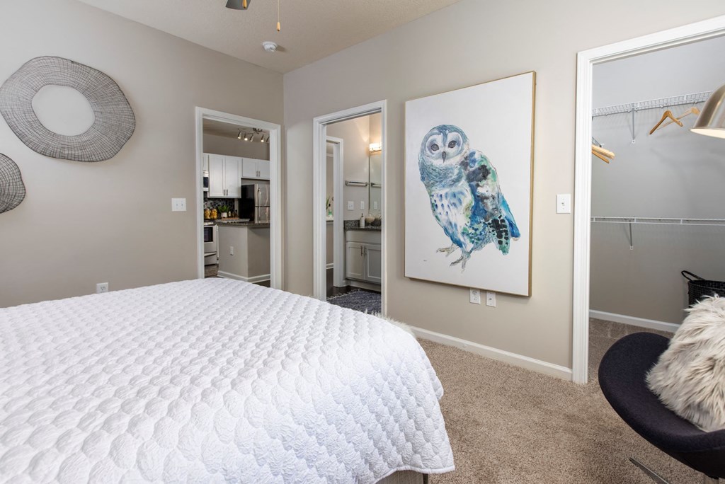 a bedroom with a white bed and a painting of an owl at Ansley at Town Center in Evans GA