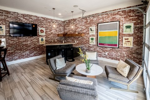 A living room with a brick wall and a fireplace.
