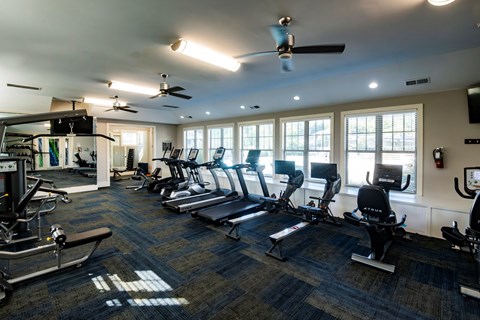 A gym with treadmills, elliptical machines, and other exercise equipment.