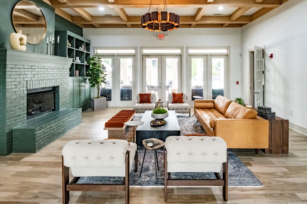 A living room with a green fireplace and a large chandelier at Ansley at Town Center Apartments, Georgia, 30809