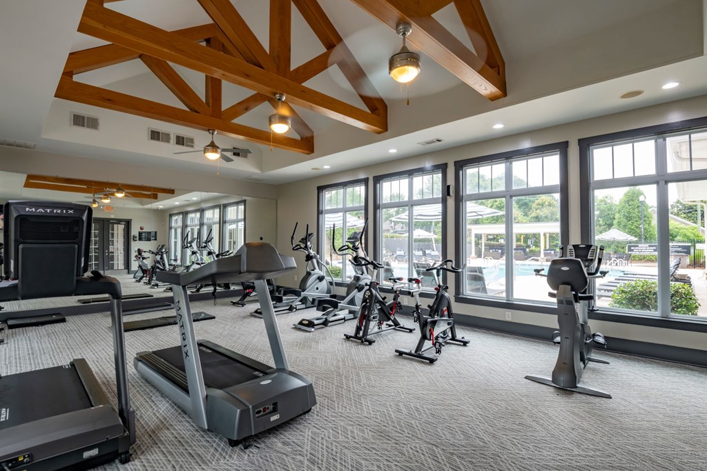 A gym with treadmills, elliptical machines, and a television at Ansley at Town Center Apartments, Evans