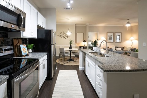 A modern kitchen with a black refrigerator and stove top oven.