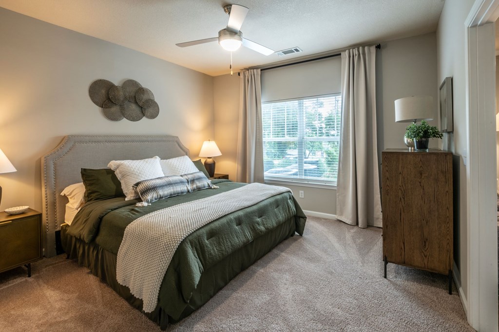 A bedroom with a large bed and a ceiling fan at Ansley at Town Center Apartments, Evans, GA 30809
