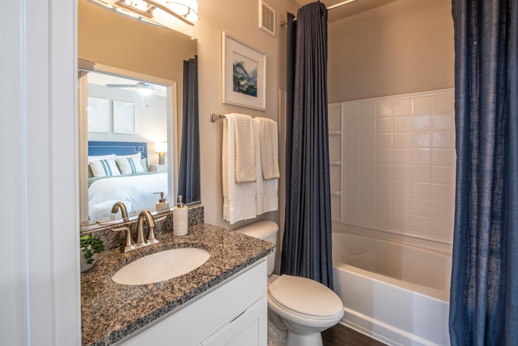 A bathroom with a sink, toilet, and a window.