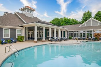 A swimming pool is surrounded by a covered patio area.