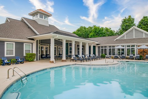 A swimming pool is surrounded by a covered patio area.