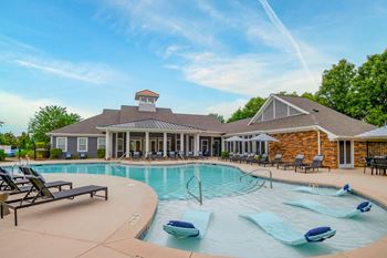 A pool with a house in the background.