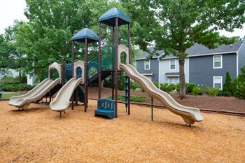 A playground with a brown slide and a green and blue structure.