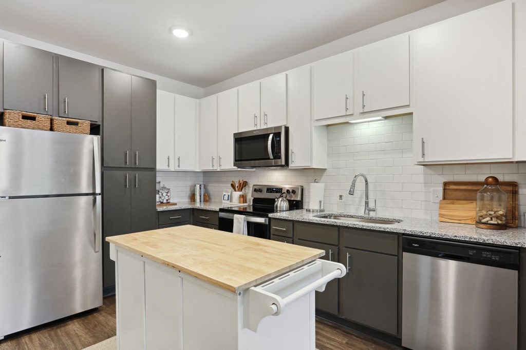 A modern kitchen with a wooden countertop and stainless steel appliances. at Arcadia Cartersville Apartments, Georgia, 30121