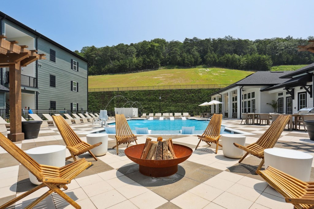 A large outdoor patio with a pool and chairs at Arcadia Cartersville Apartments, Cartersville, GA