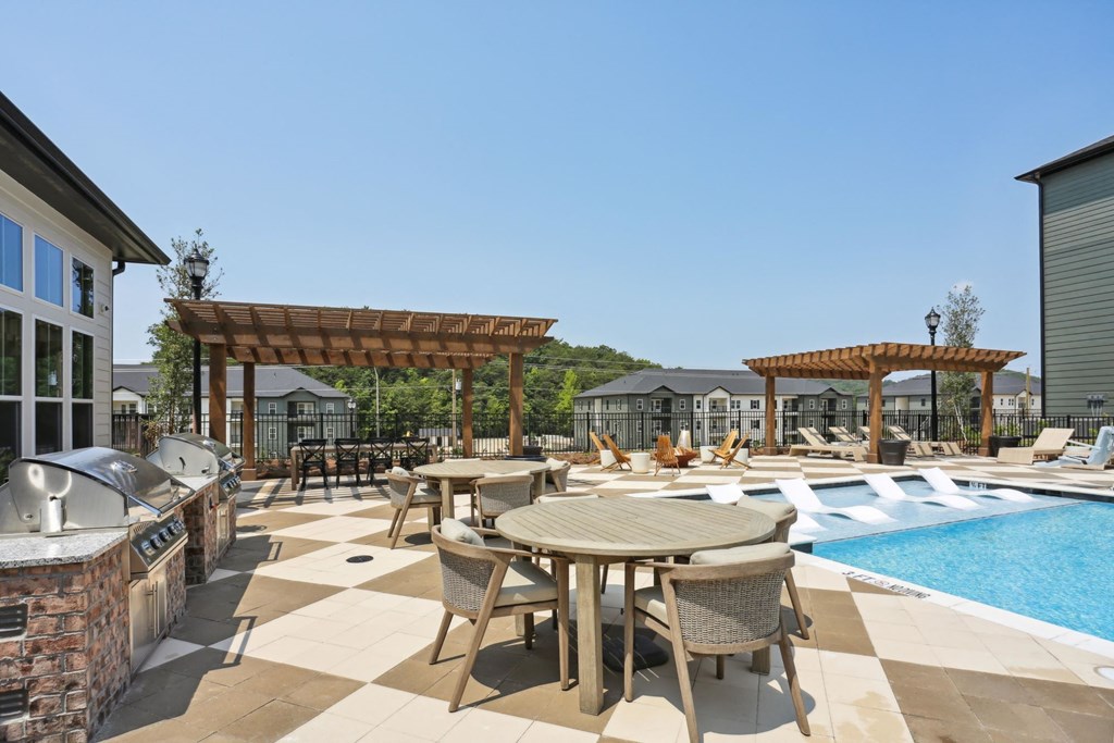 A poolside patio with a table and chairs at Arcadia Cartersville Apartments, Cartersville, 30121