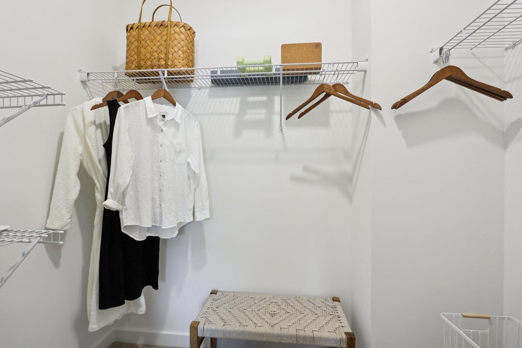 A white shirt is hanging on a hanger in a closet at Arcadia Cartersville Apartments, Cartersville, Georgia