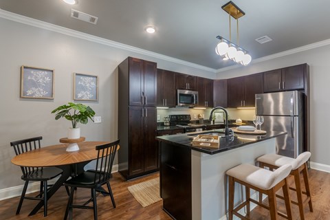 A kitchen with a table and chairs.