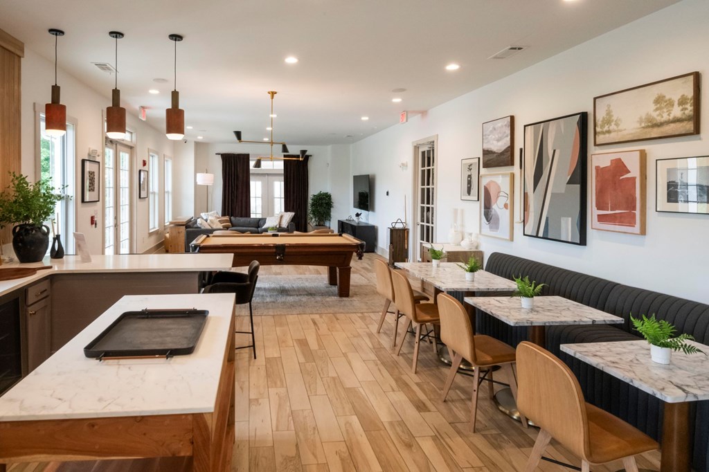 A modern kitchen and dining area with wooden floors and furniture.