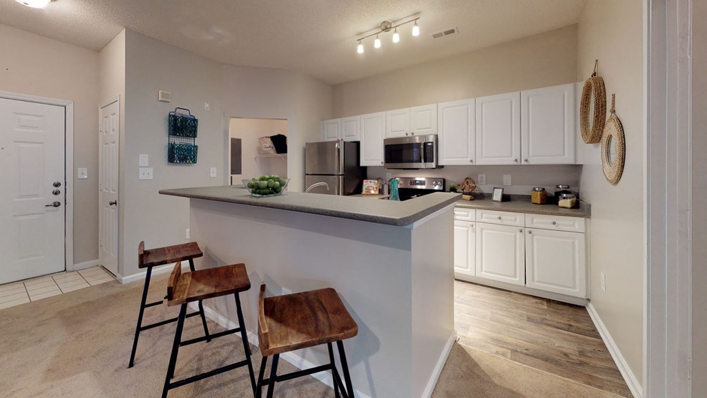 a kitchen with a large island with two stools in front of it at Autumn Park Apartments, Charlotte, NC, 28262