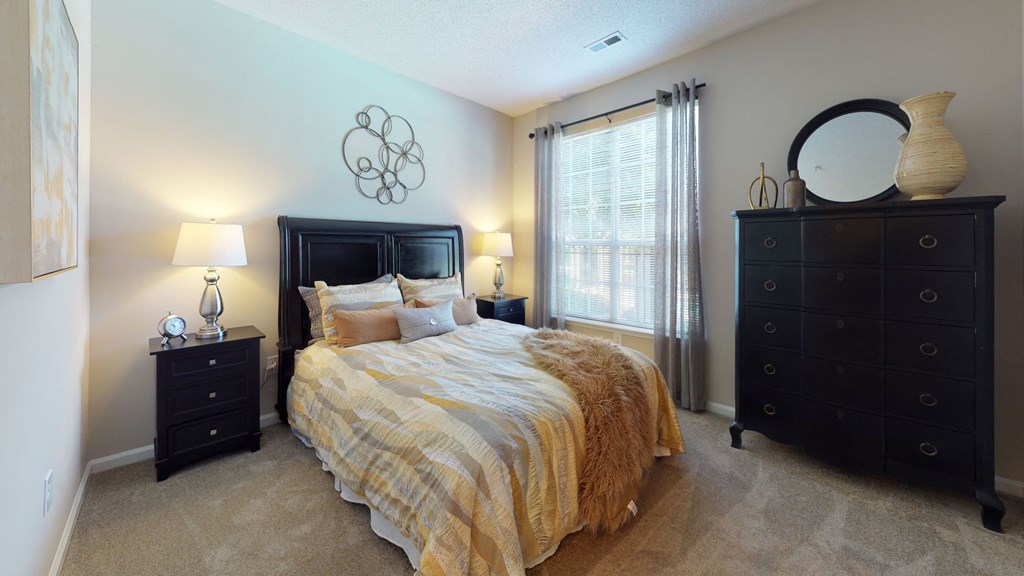 a bedroom with a bed and two dressers at Autumn Park Apartments, Charlotte, NC, 28262