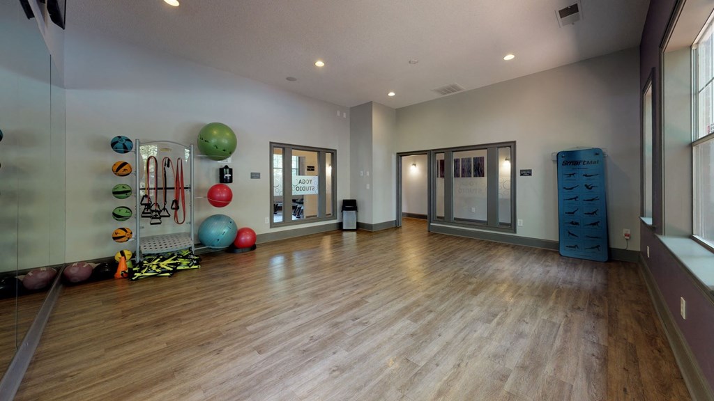 a large fitness room with hardwood floors and a large window at Autumn Park Apartments, Charlotte