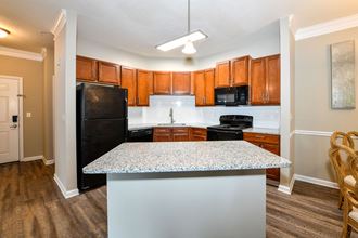 a kitchen with a granite counter top and a black refrigerator