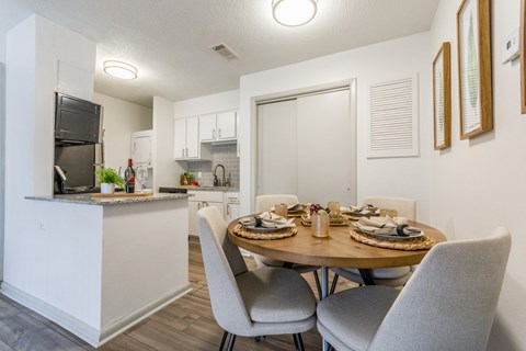 A modern kitchen with a dining table set for two.